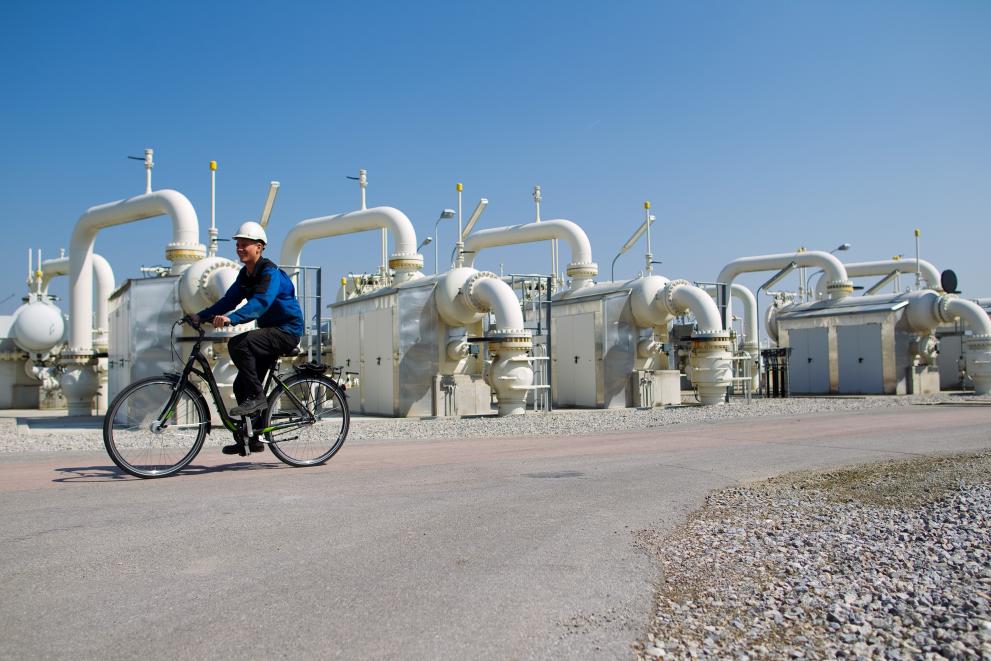 A staff member on a bicycle passing by filter separators used for natural gas cleaning