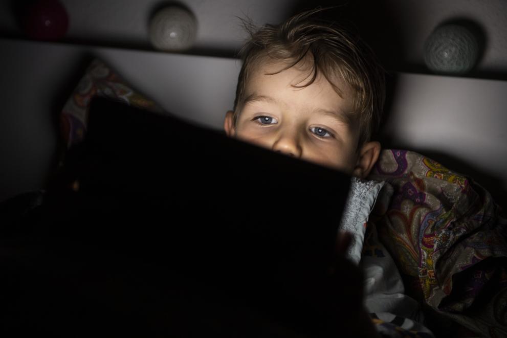 A child in bed with a tablet